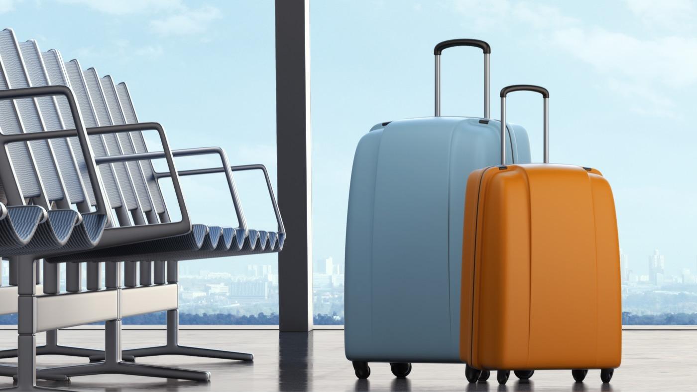 Travelers' luggage beside seating in an airport lounge